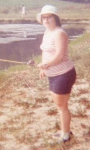 Adult with bucket hat and Down Syndrome fishing