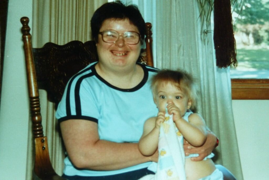 Woman with Down syndrome holding toddler girl with blanket