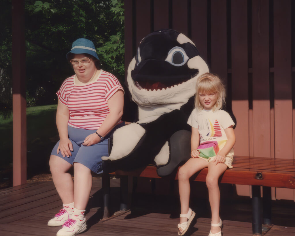 Adult and child sitting with Shamu