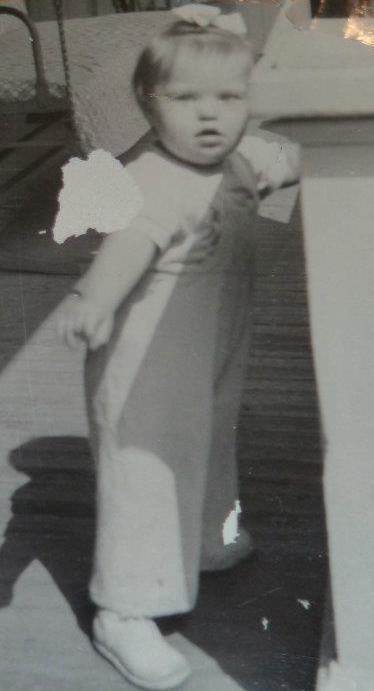 Toddler with Down Syndrome standing at a wall in the 1940s