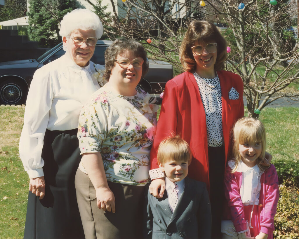 Grandma, aunt, mother and 2 children posing in front of tree decorated with Easter eggs