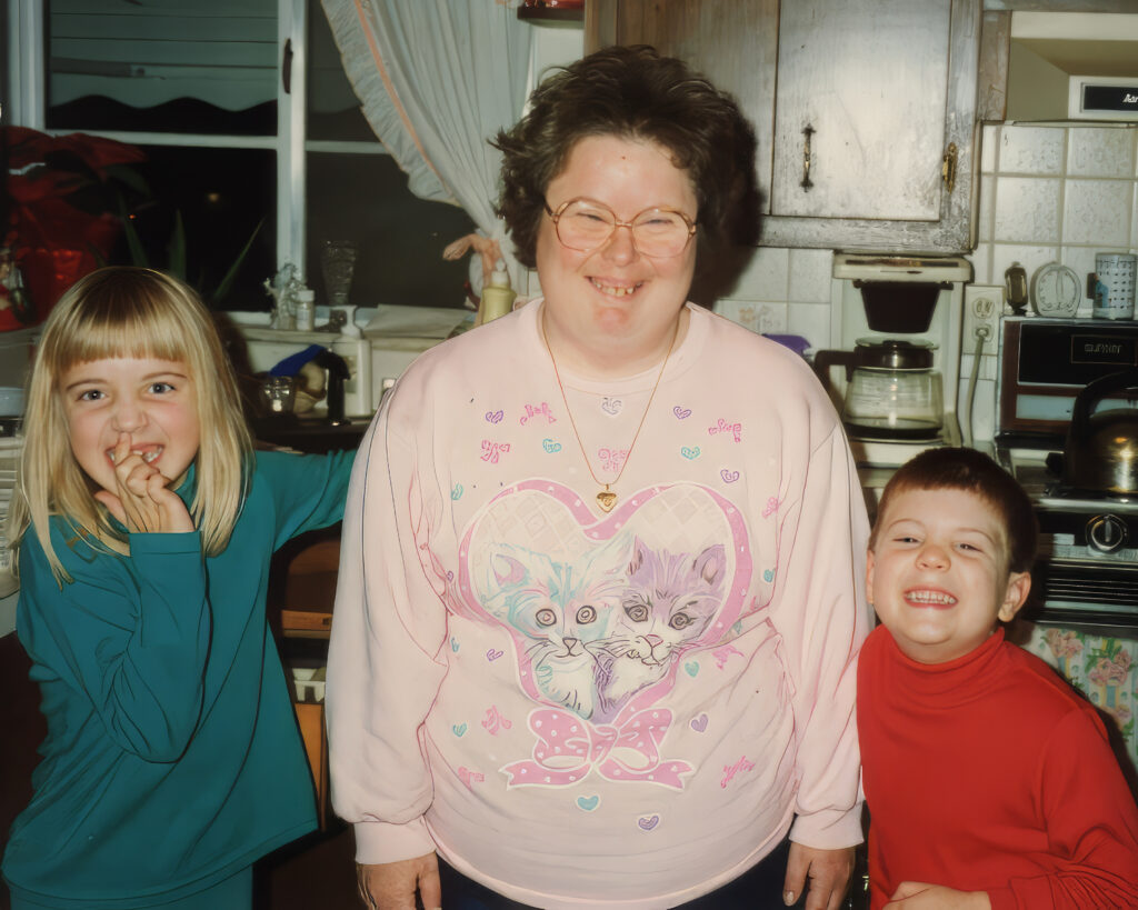 1 female child and one male child standing and smiling with adult smiling with glasses